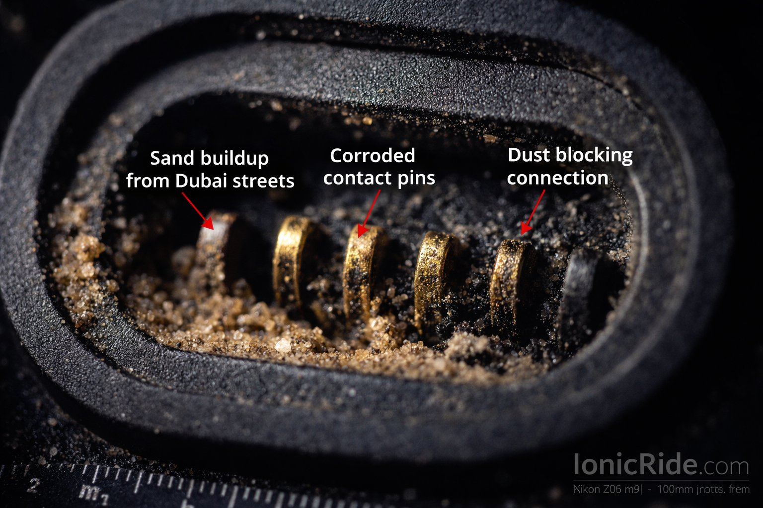 Detailed close-up of e-scooter charging port showing dust buildup, bent pins, and corrosion damage common in Dubai's dusty conditions