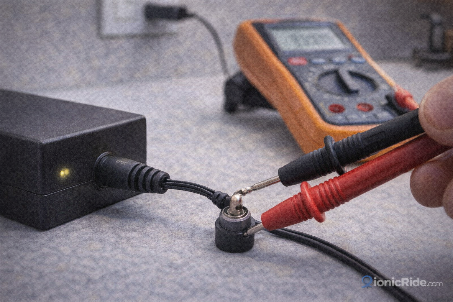 Voltage test with multimeter probes on an e-scooter charger output connector to confirm correct DC charging voltage